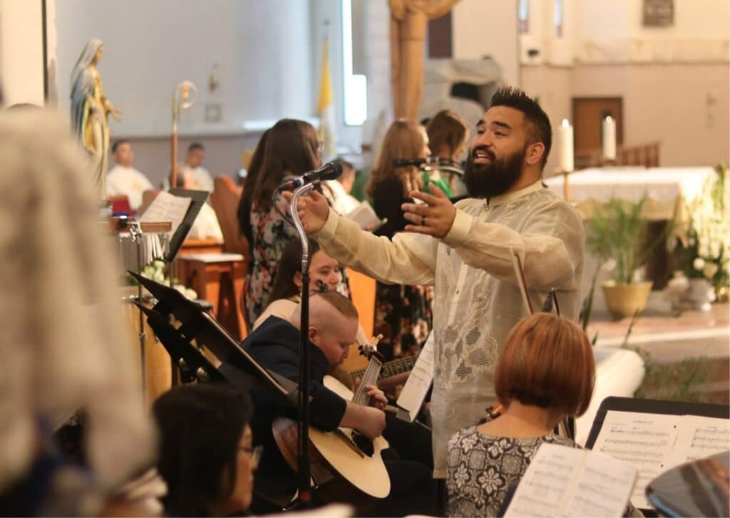 Man leading a musical group in song